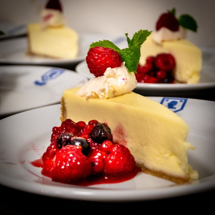 Cheesecake with whipped cream, a raspberry and berry compote